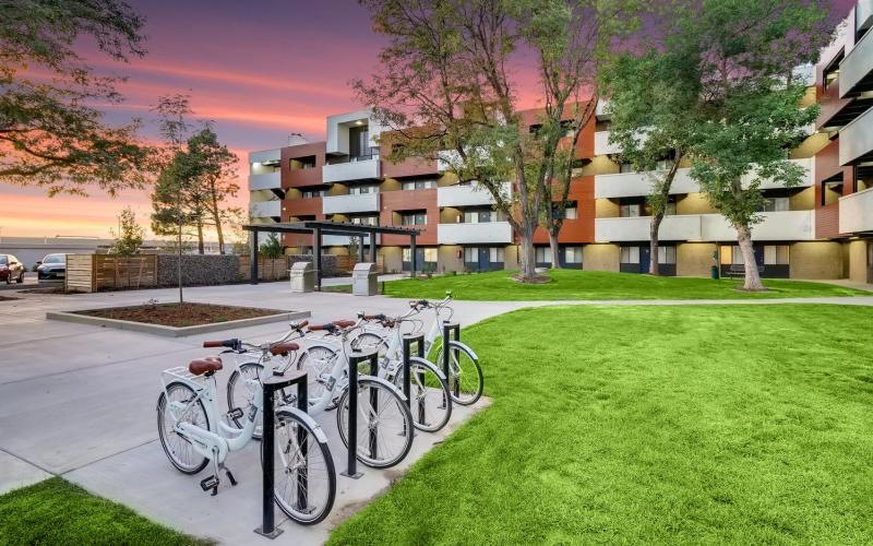 a row of bicycles parked on a sidewalk in front of a building